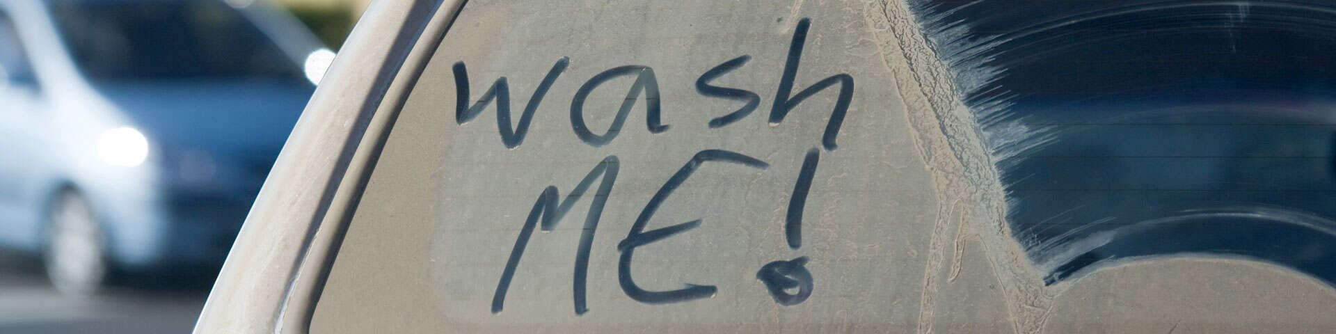 "Wash me" phrase on a dirty car window